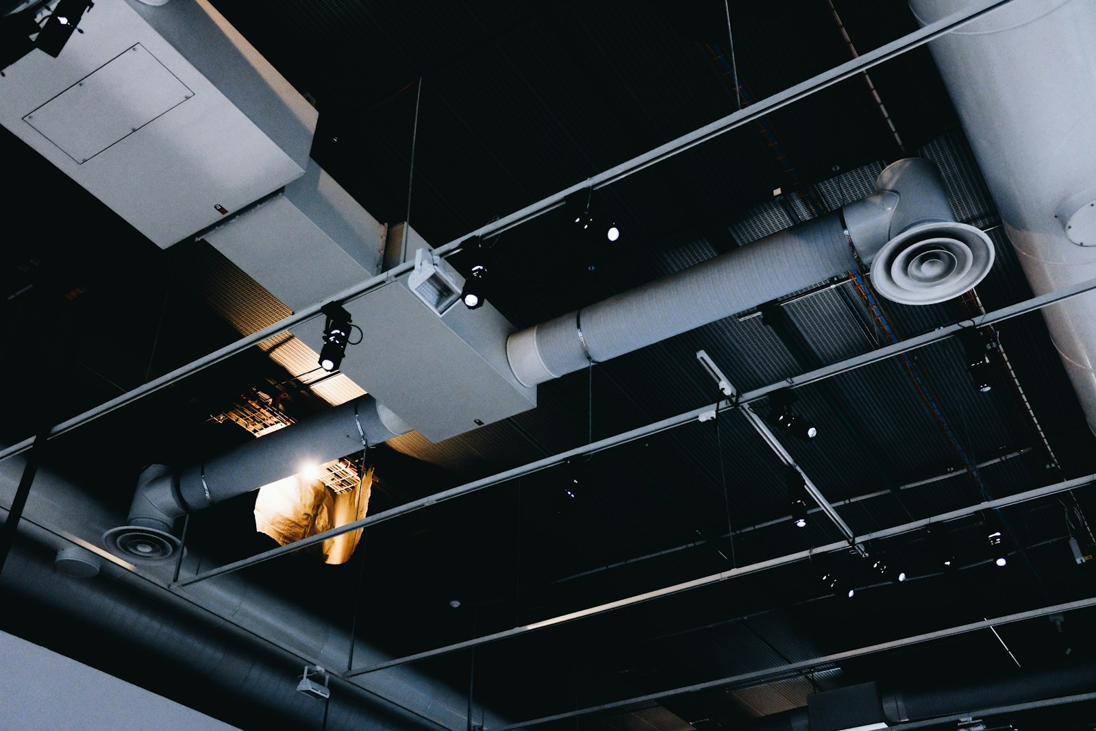 Heat recovery ventilator (HRV) unit connected to insulated ventilation ducts in a residential utility space