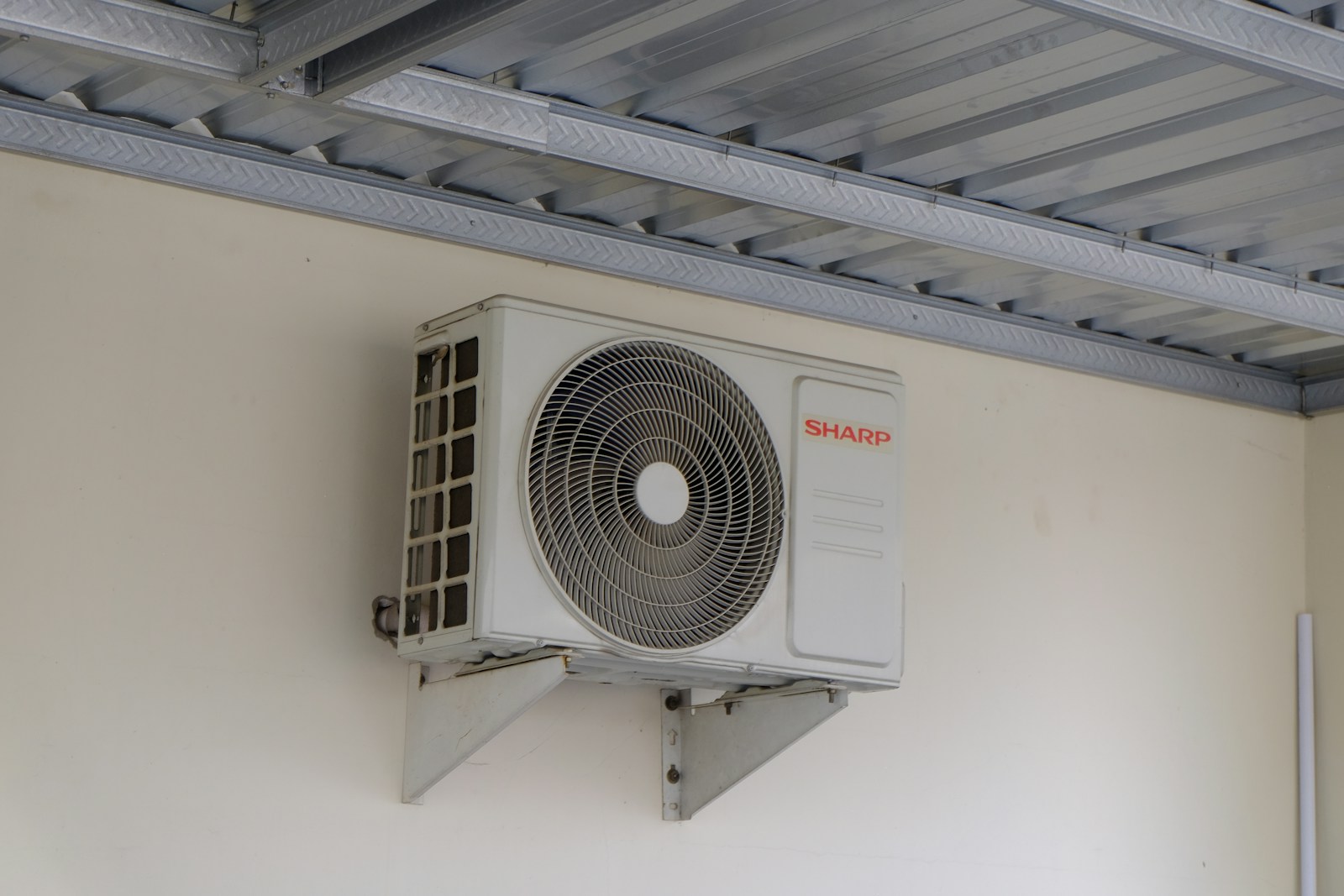 Close-up of a white wall-mounted ductless mini split indoor unit installed near the ceiling of a home